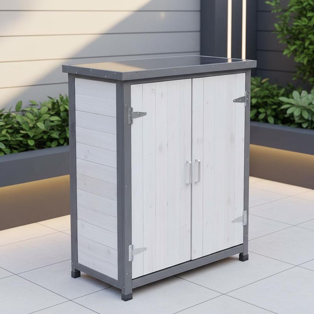 A white and gray wooden garden cabinet with two doors is shown outdoors on a tiled patio. Green plants are visible in the background.