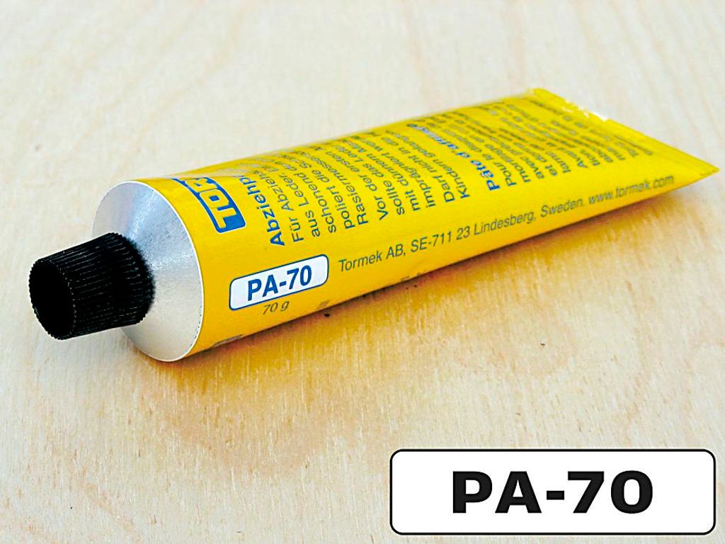 A tube of Tormek PA-70 polishing paste on a wooden surface.