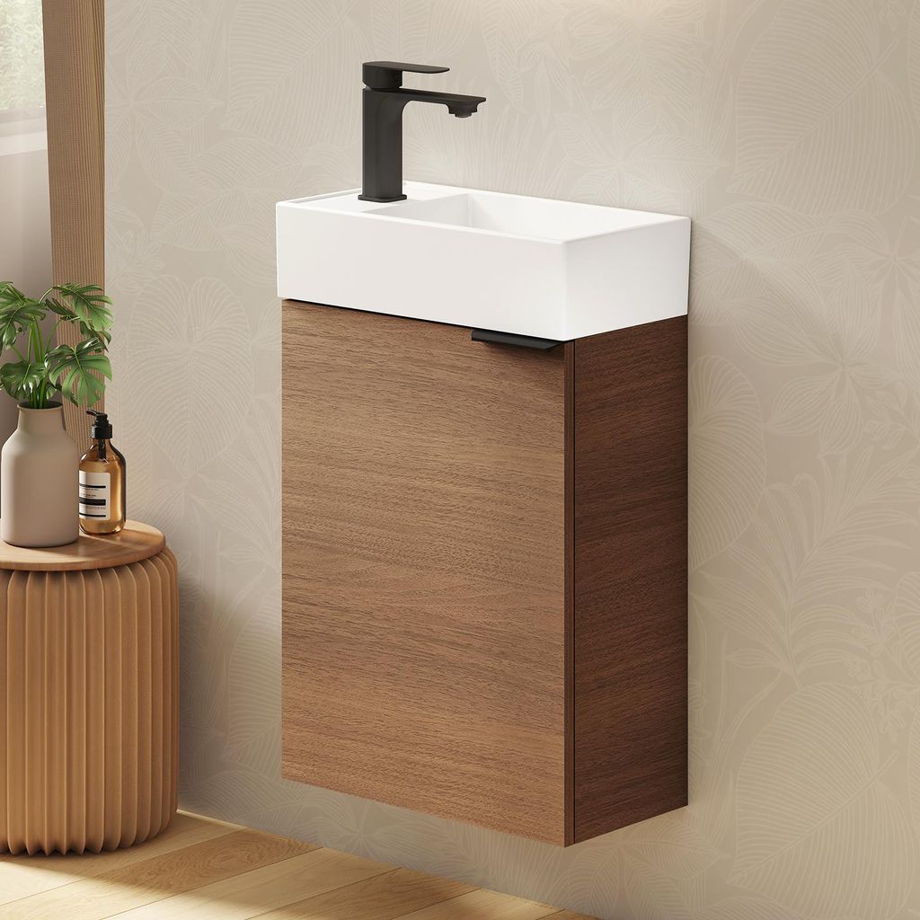 A modern wall-mounted bathroom vanity with a white ceramic sink and a dark wood cabinet, set against a textured wall.