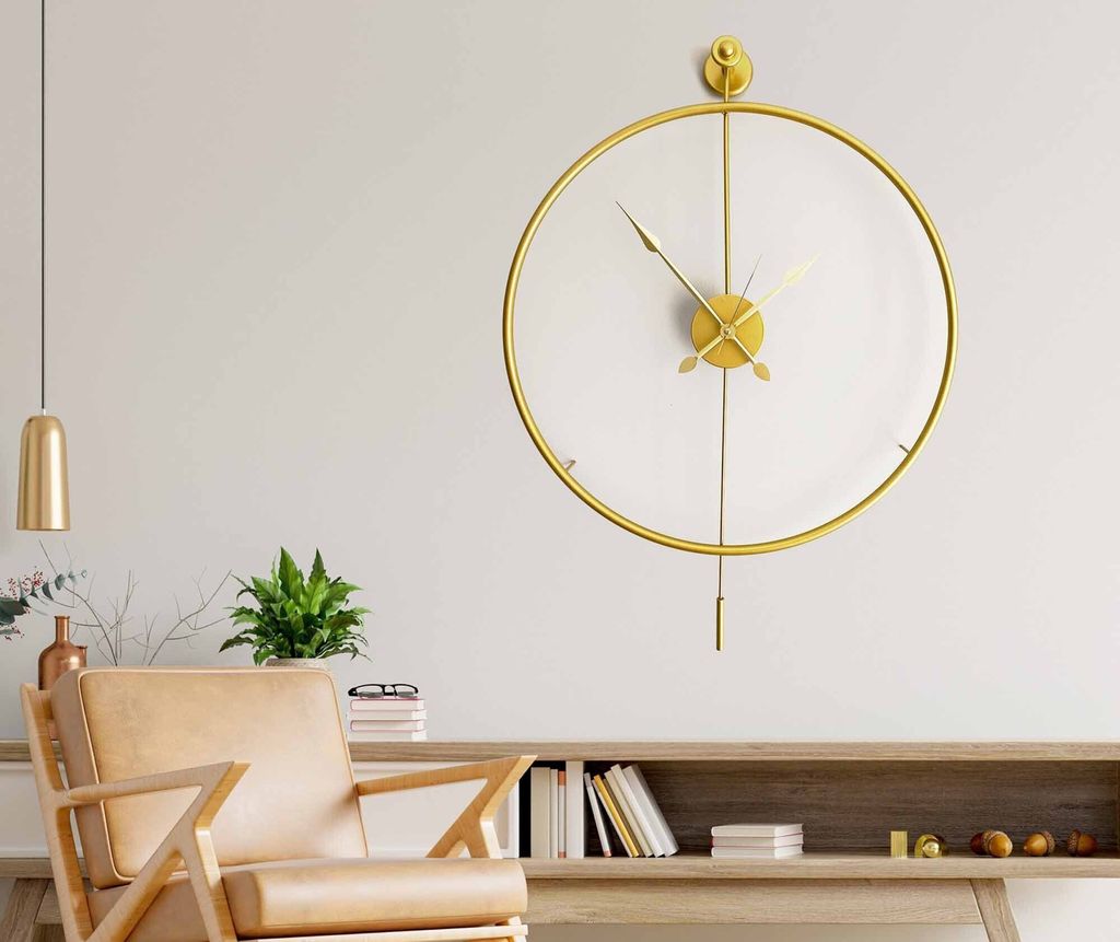 A modern living room with a gold pendulum clock on the wall, a wooden chair, and a wooden cabinet with books.