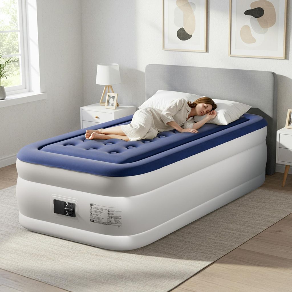 A woman is sleeping on an inflatable mattress in a bedroom.