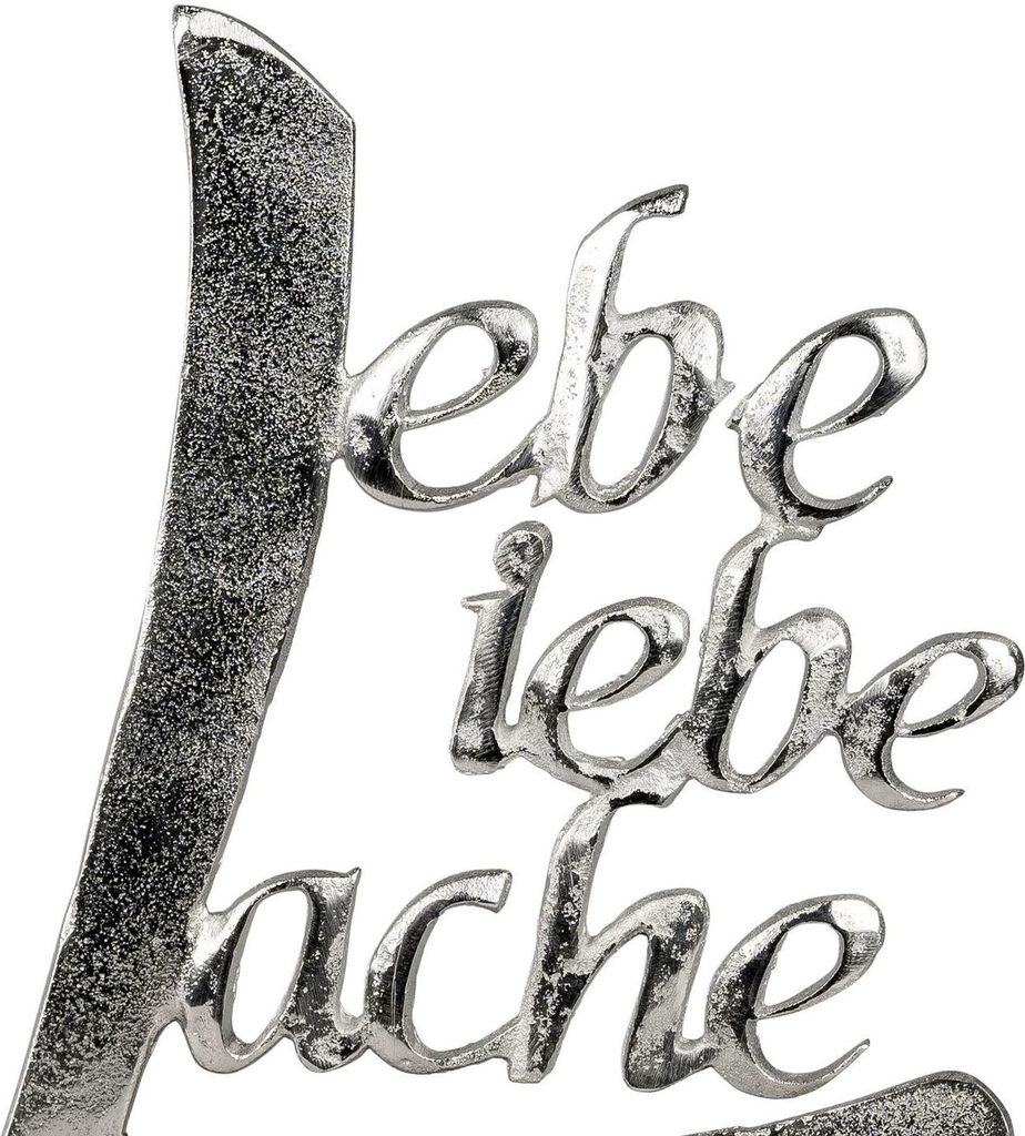 A close-up of a metallic decorative text sign.