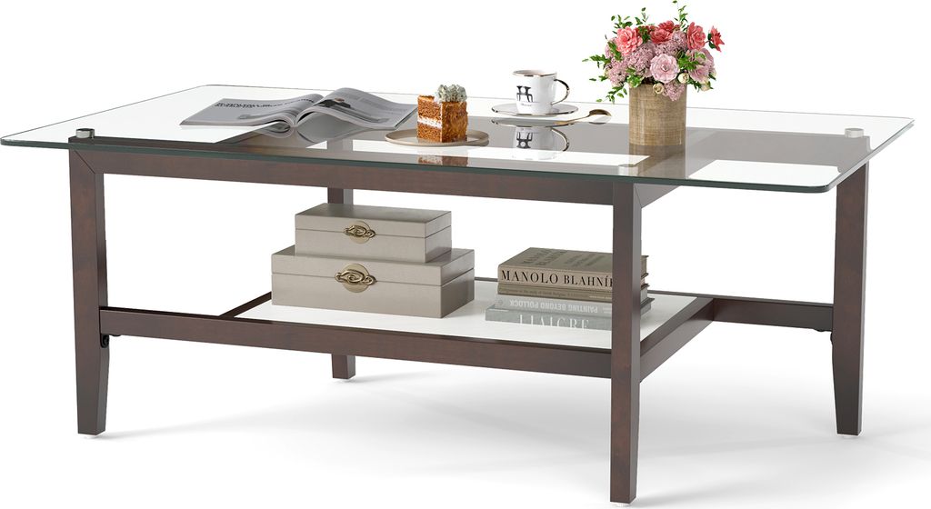 A glass-top coffee table with a wooden frame and a lower shelf, decorated with books, boxes, and a vase of flowers.