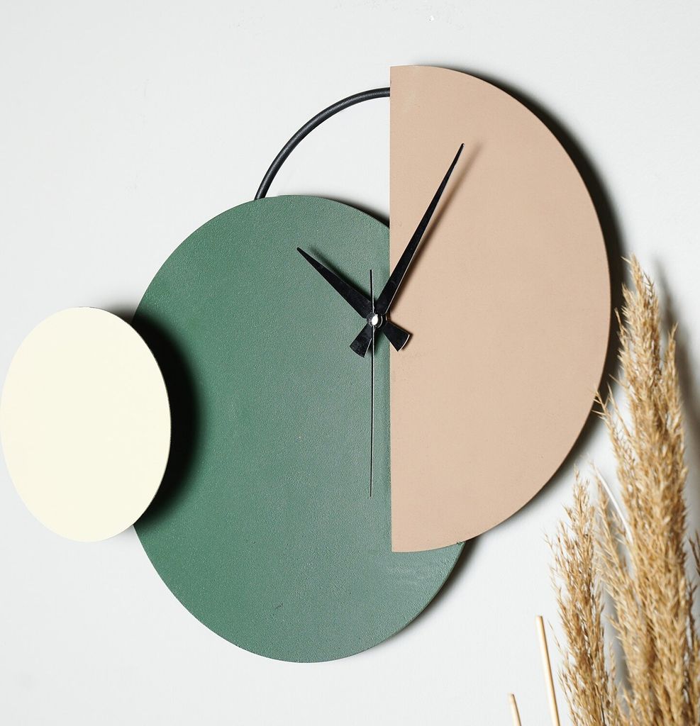 A modern, abstract wall clock with geometric shapes and black hands.