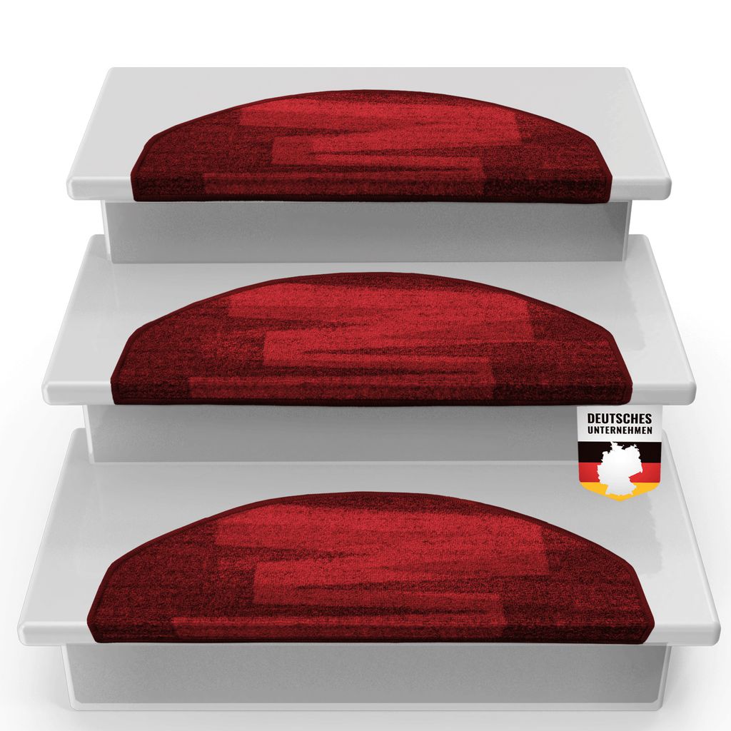 Three red, half-round stair mats are stacked on white steps.