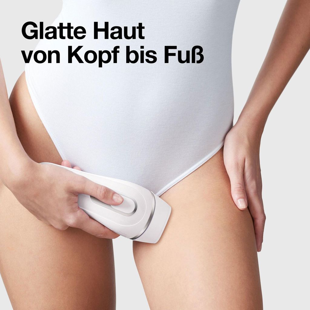 A person is using an IPL hair removal device on their thigh.