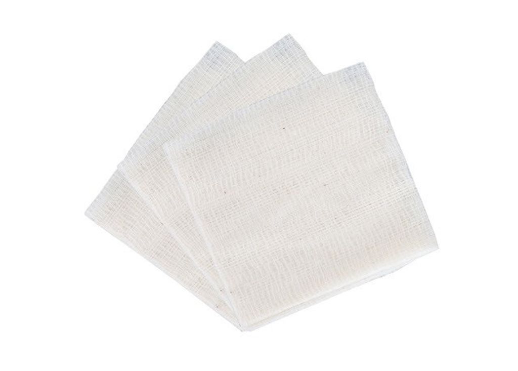 A stack of white gauze pads on a white background.
