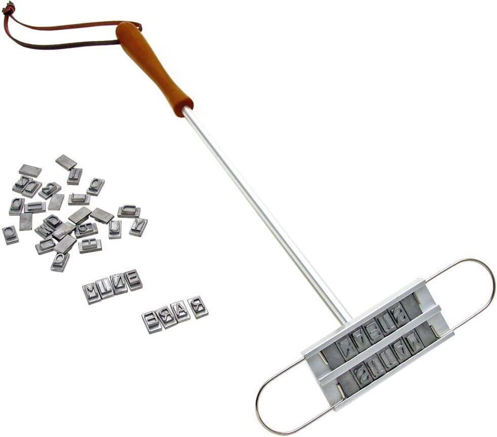 A meat branding iron with interchangeable letters and a pile of letters.