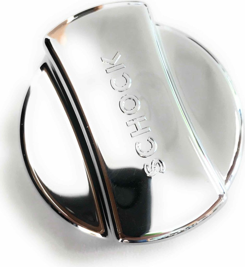 A close-up, studio shot of a chrome-plated sink drain knob with the word "SCHOCK" embossed on it.