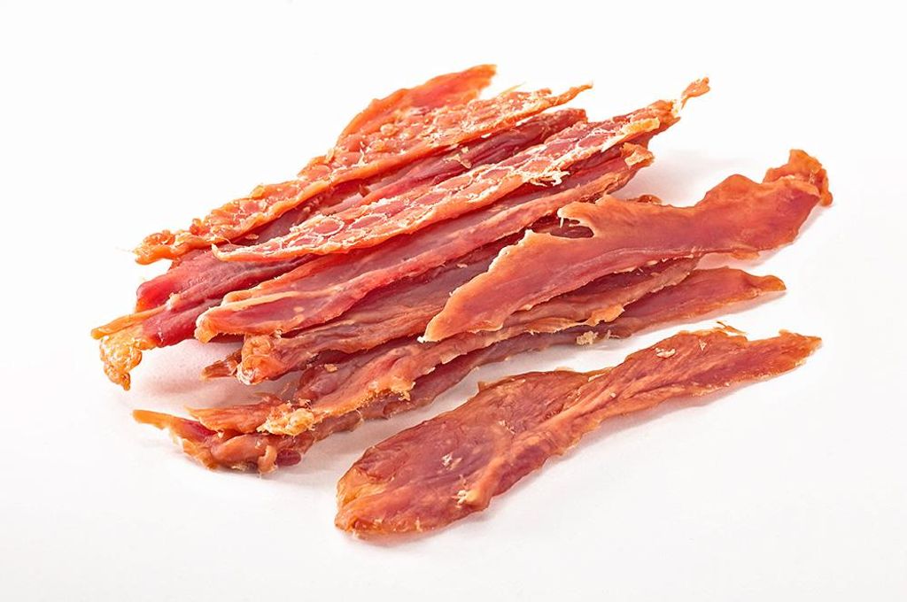 A pile of dried meat strips on a white background.