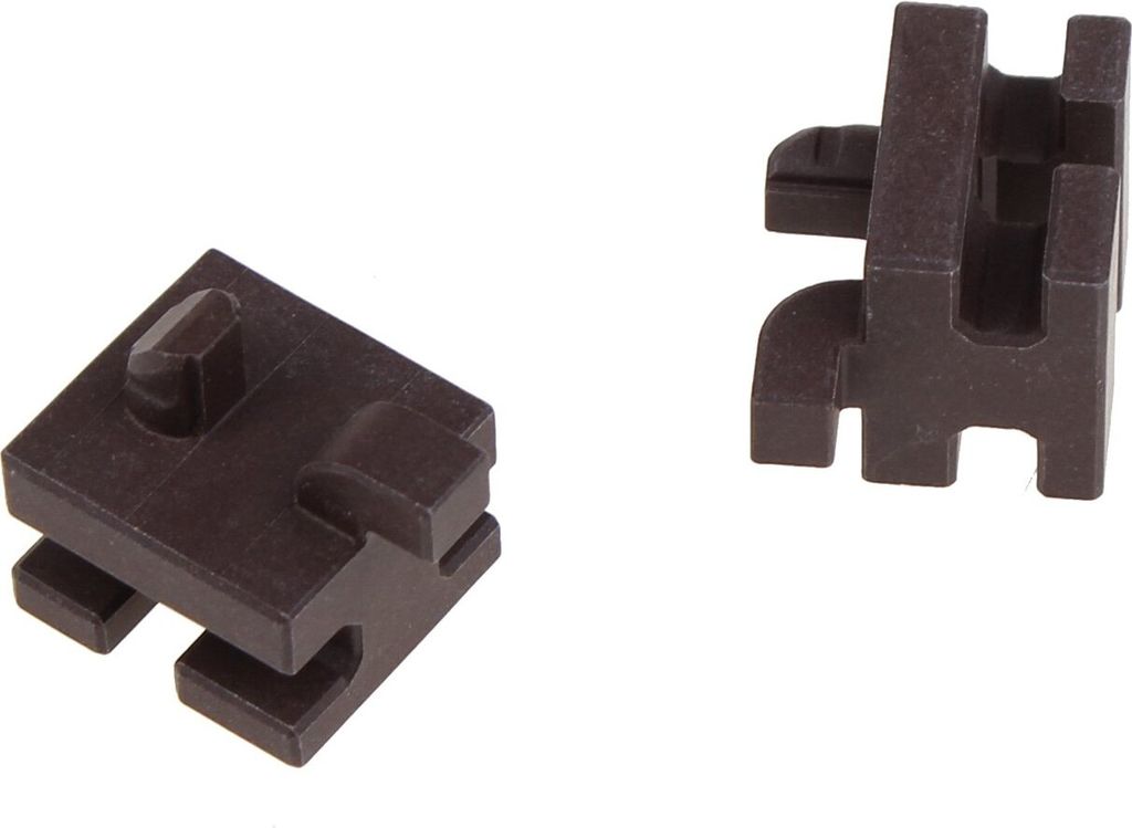 Two dark brown plastic components are shown against a white background. The component on the left is a square-like piece with a protruding peg on top and interlocking slots on the bottom. The component on the right is an L-shaped piece with a slot on top a
