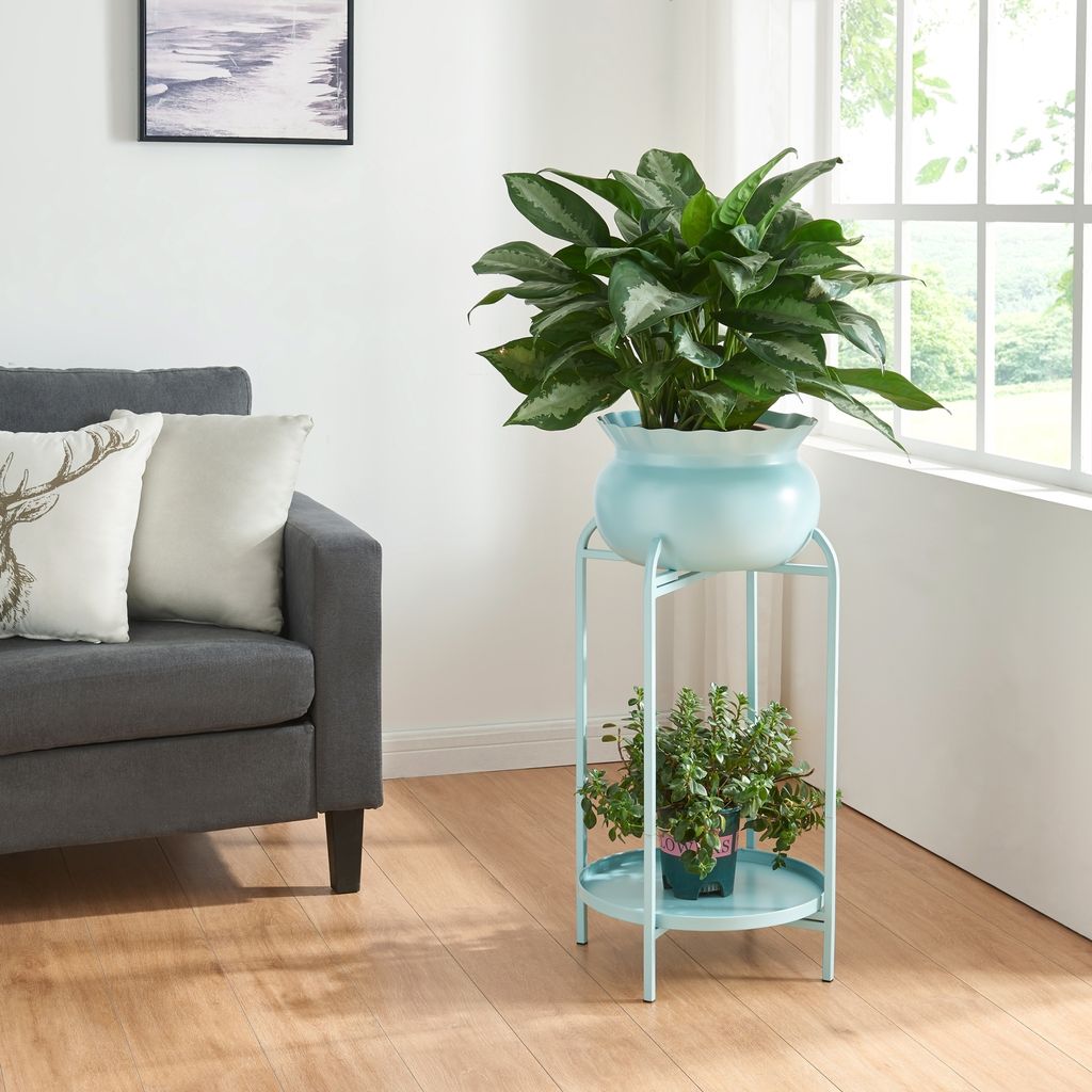 A living room scene with a sofa and a plant stand with plants.
