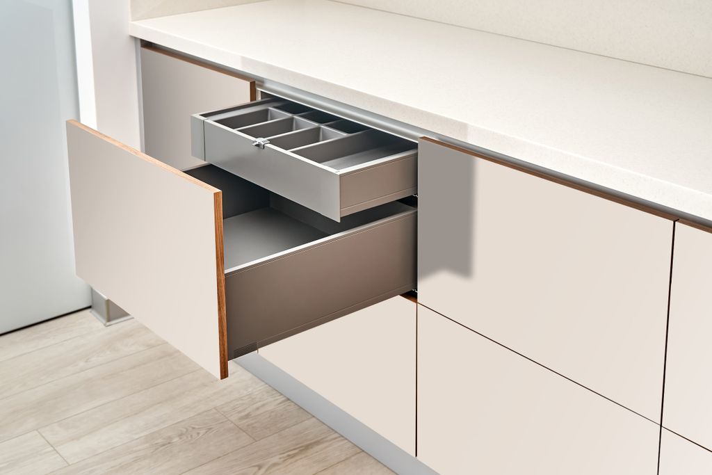 A close-up view of kitchen drawers, one of which is open to reveal an organizer tray.