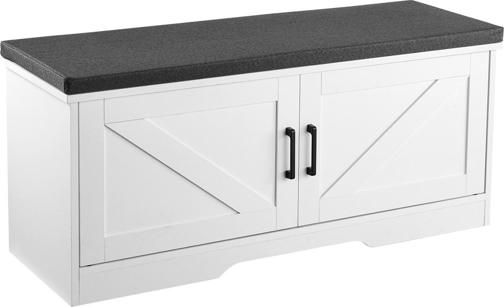 A white shoe bench with a dark gray upholstered seat and two barn-style doors with black handles.