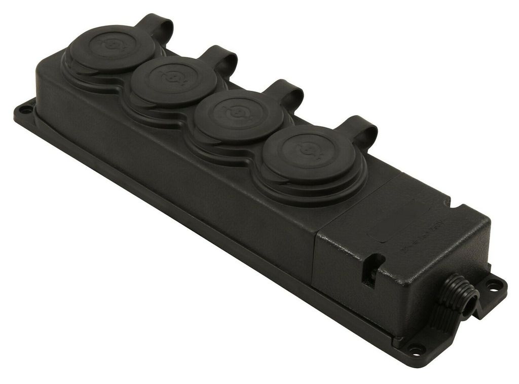 A black electrical multi-socket outlet with four covered sockets and a cable entry point, shown from a diagonal angle on a white background.