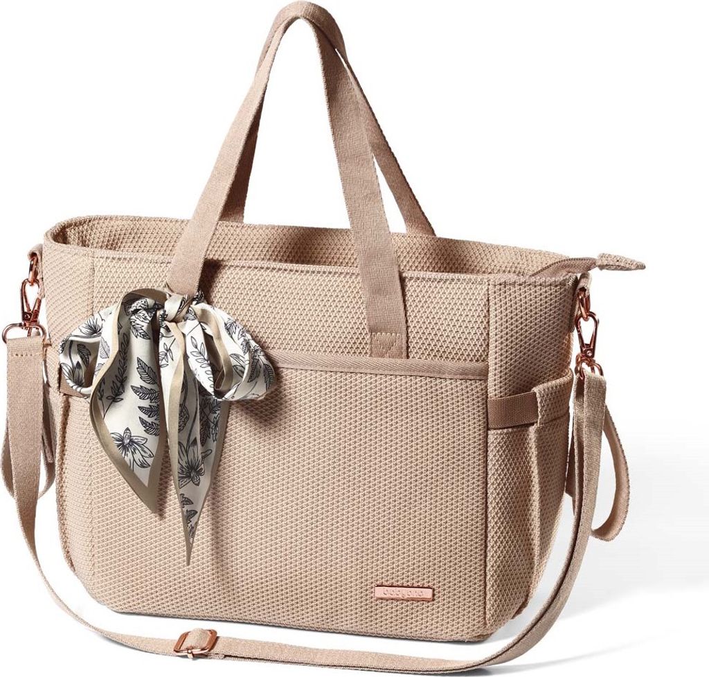 A studio shot of a beige diaper bag with a patterned scarf tied to the handle.