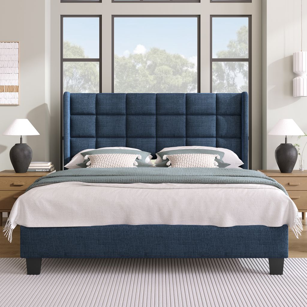 A bedroom scene with a blue upholstered bed as the main focus, set against a backdrop of large windows and subtle wall decor.
