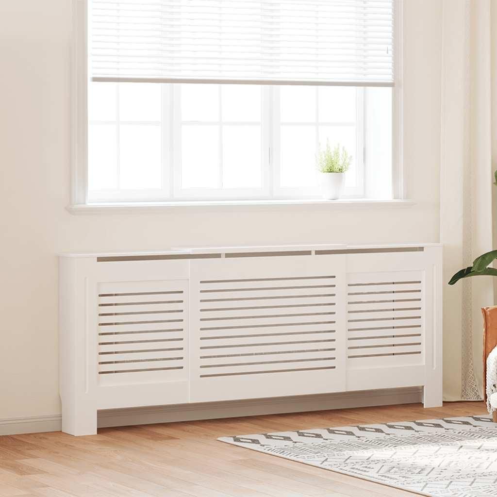 A white radiator cover is placed in front of a window with white blinds.