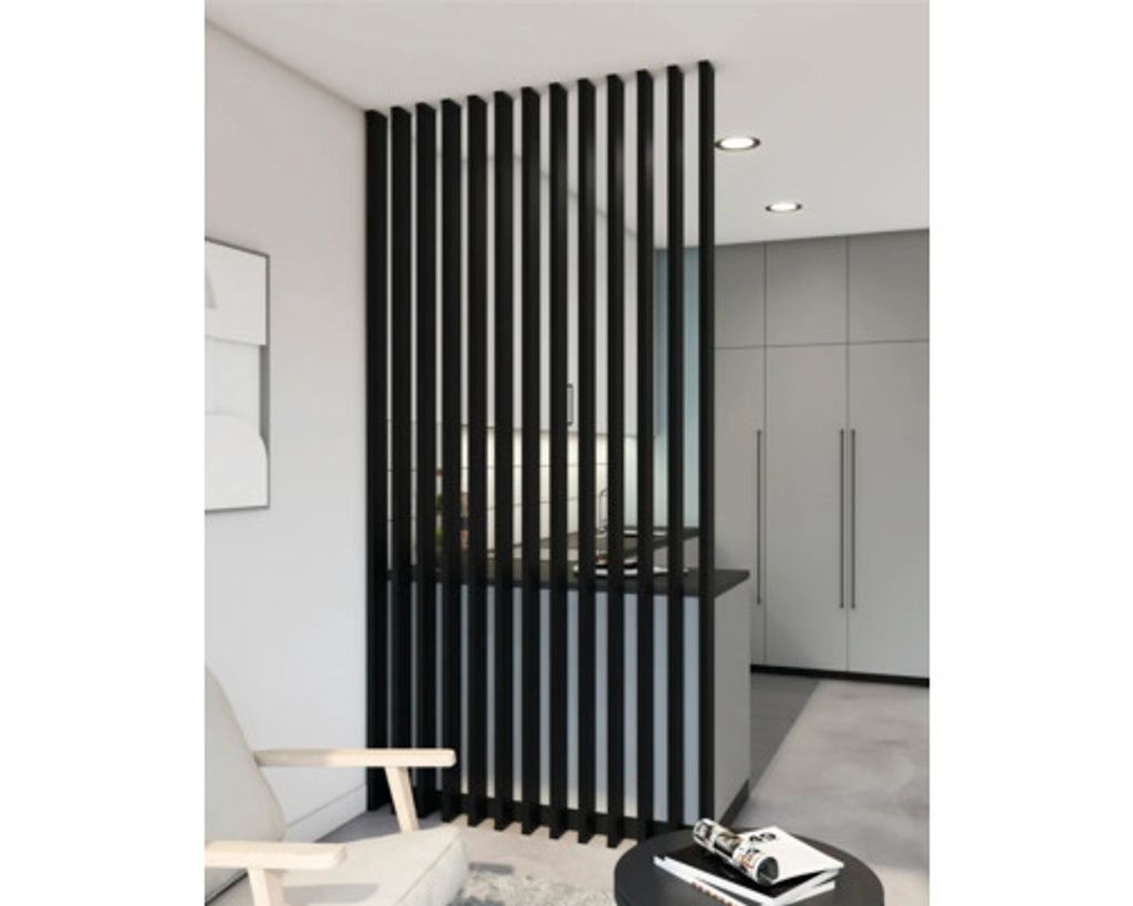 A modern interior with a black slatted room divider separating living and kitchen areas.