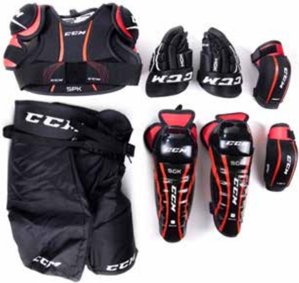 A collection of hockey protective gear laid out on a white background.