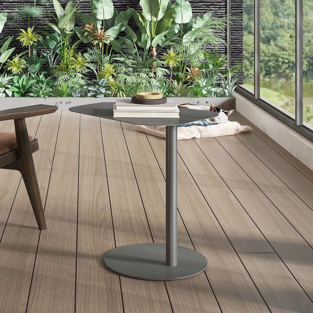 A modern balcony setting with lush greenery, a table, and a chair.