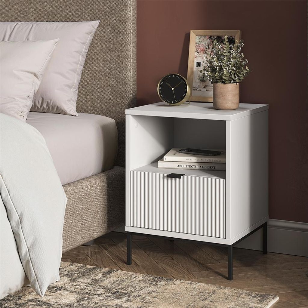 A bedside table next to a bed.