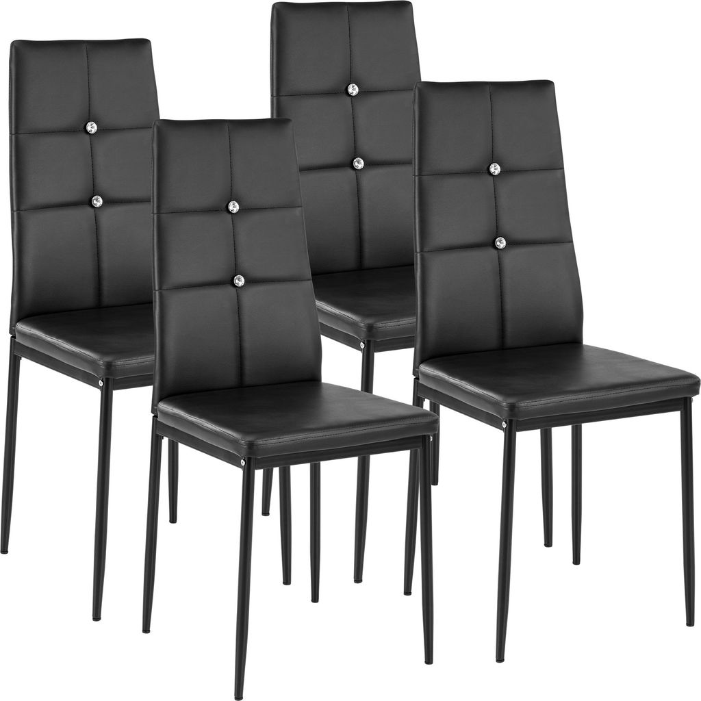Four black dining chairs against a white background.