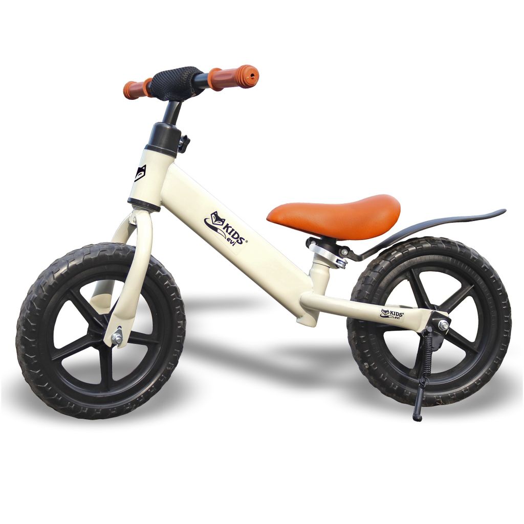 A cream-colored balance bike for children with orange handlebars and seat, shown against a white background.
