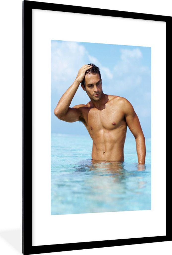 MuchoWow Gerahmtes Poster Ein muskulöser Mann steht im Ozean 60x90 cm - Poster mit Schwarzem Bilderrahmen Wandposter Rahmen Foto Bilder - Dekora...