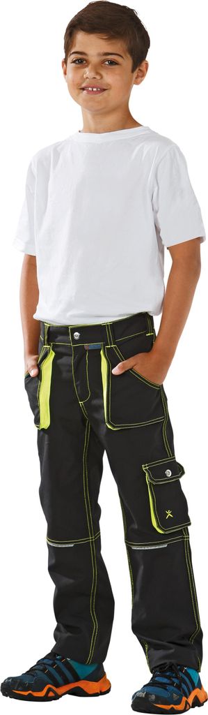 A young boy wearing work pants and a t-shirt, standing against a white background.