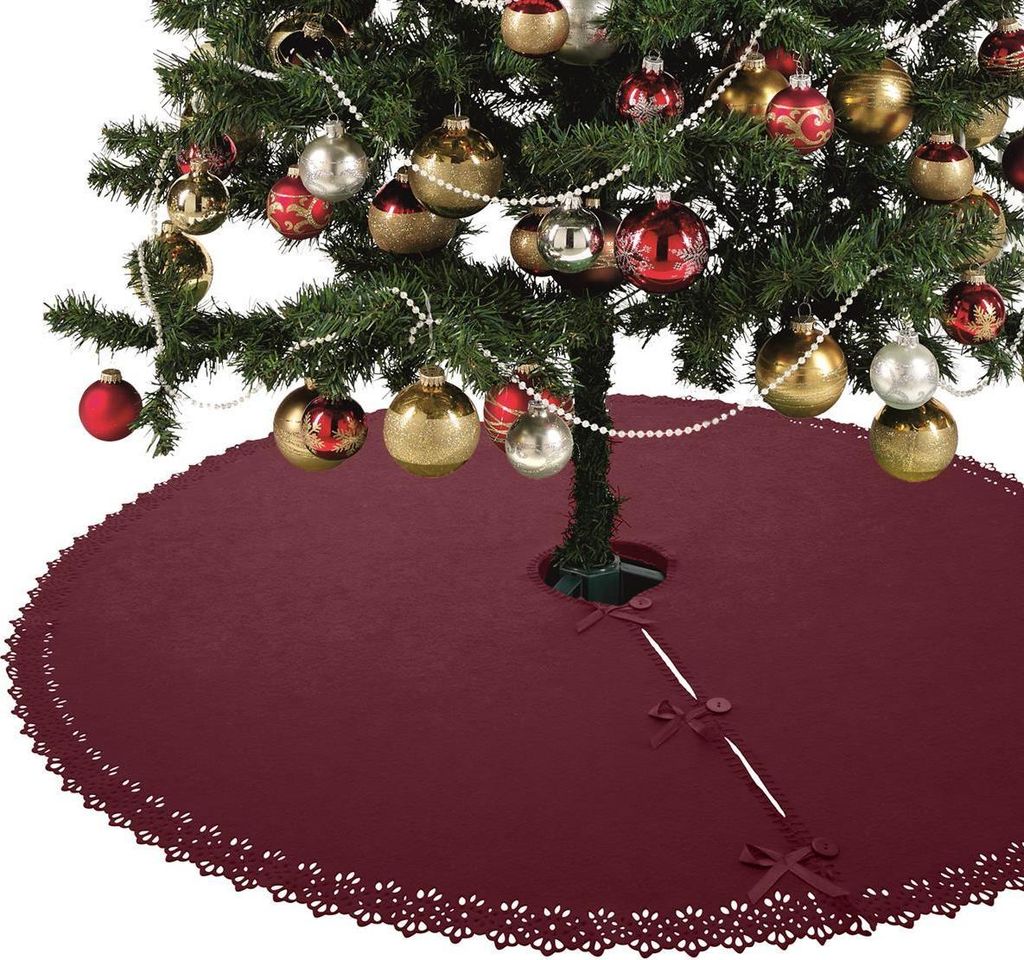 A Christmas tree decorated with ornaments and a red tree skirt.