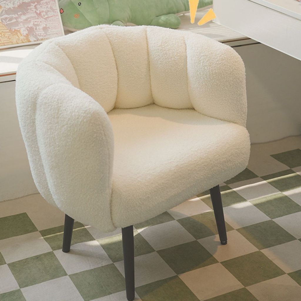 A white, fluffy armchair with a scalloped back is shown in a room with a checkered floor.