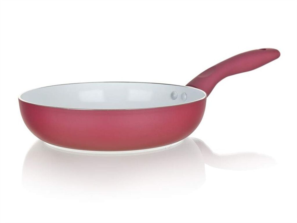 A red ceramic frying pan with a white interior and a red handle, shown from a side angle on a white background.