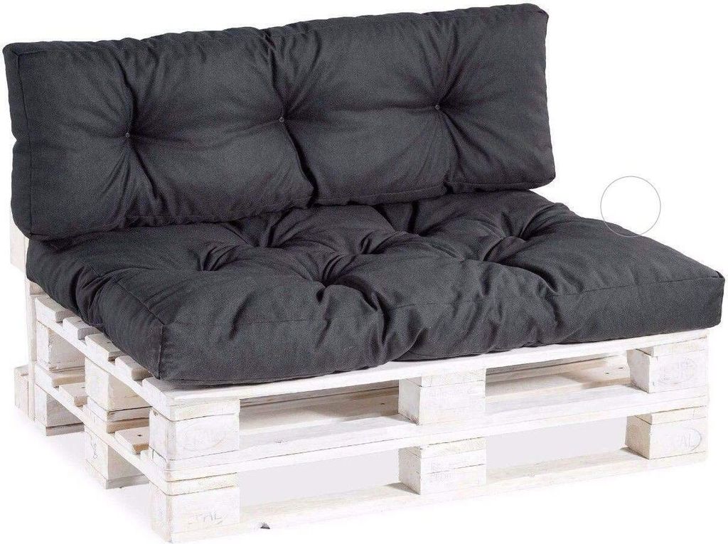 A dark gray tufted cushion set on a white wooden pallet base.