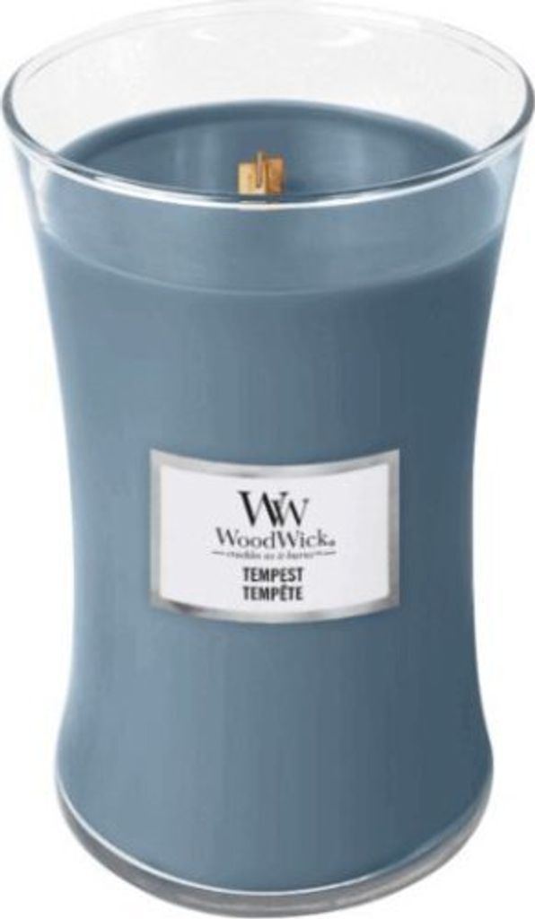 A close-up studio shot of a blue WoodWick candle in a glass jar.