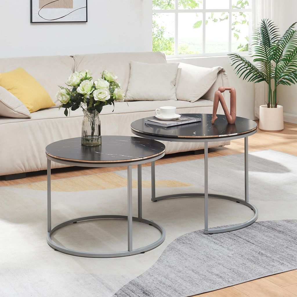 A living room scene with a couch, coffee tables, and a plant.