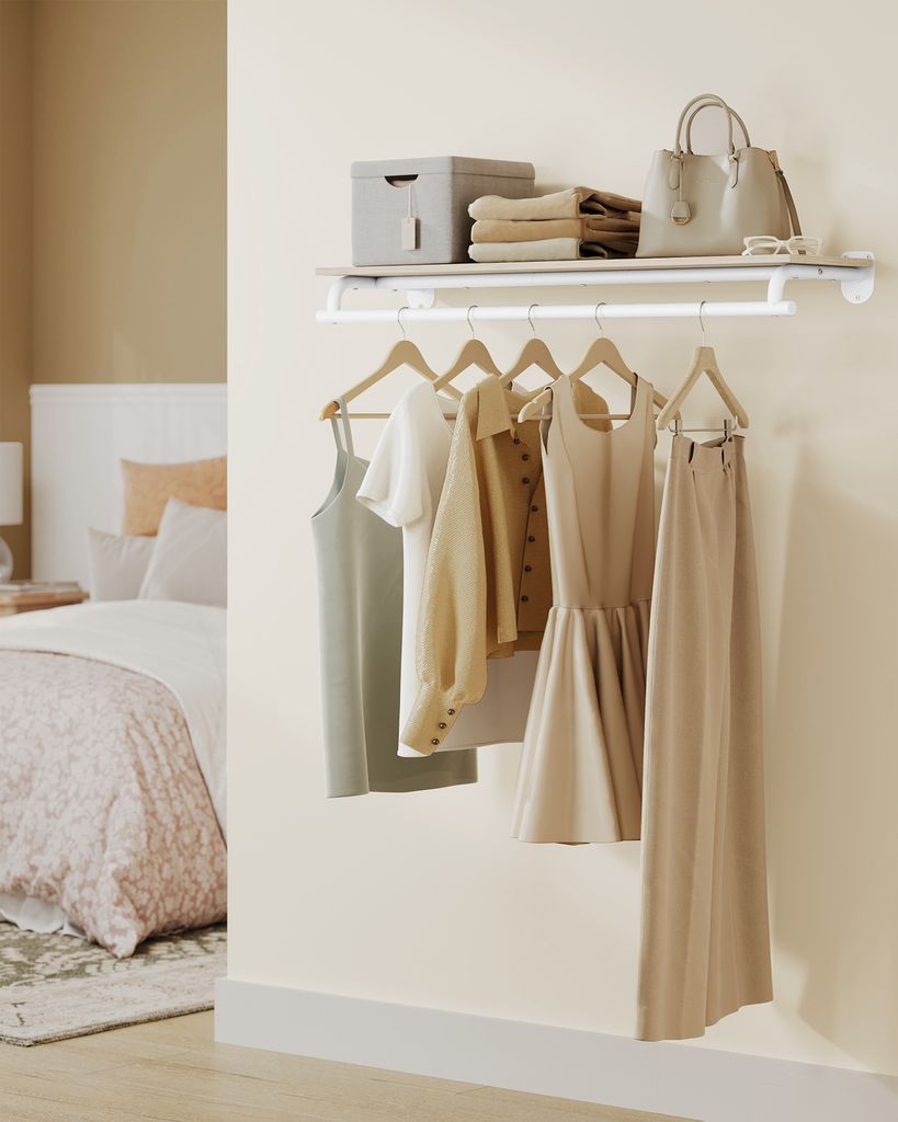 A closet rod with several garments hanging on it, and a shelf above with storage items.