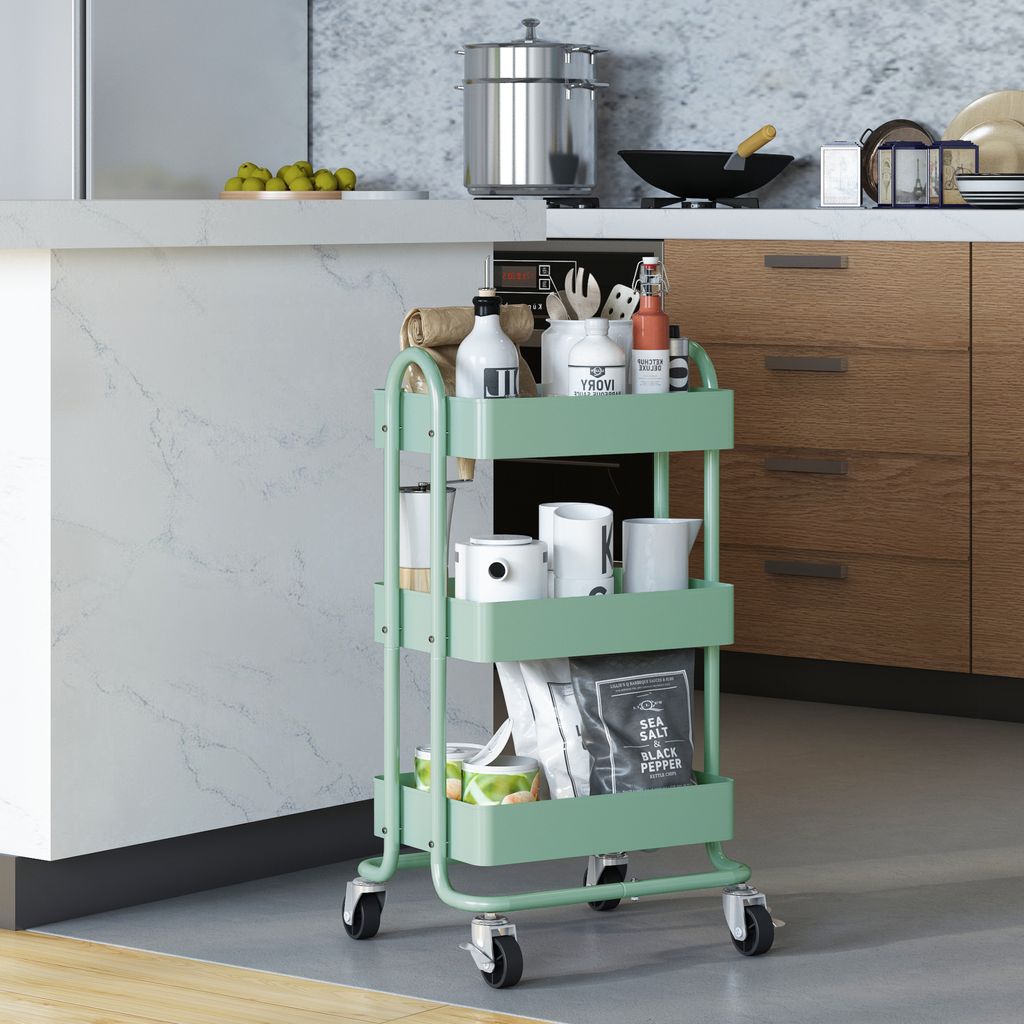 A mint green kitchen cart filled with various kitchen items, placed next to a kitchen counter and cabinets.