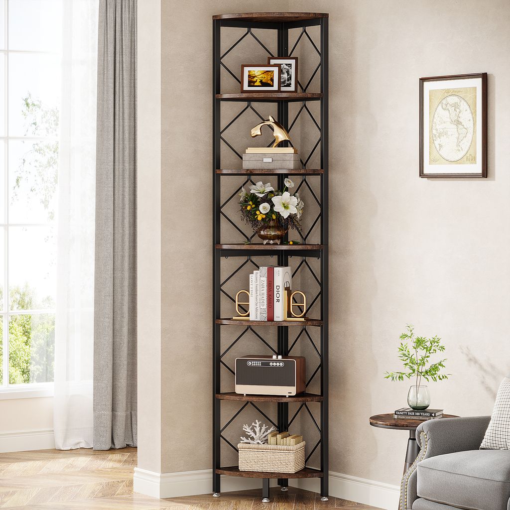 A tall corner bookshelf filled with decorative items and books, placed in a room next to a window and a chair.