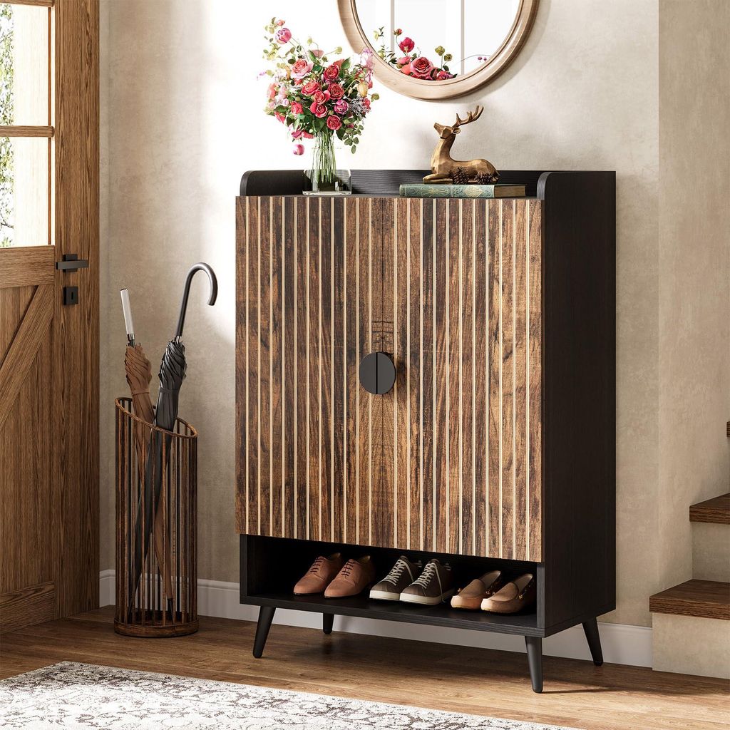 An entryway with a shoe cabinet, umbrella stand, and a door.