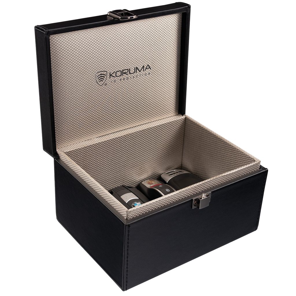An open black box with a textured interior, containing three car key fobs.