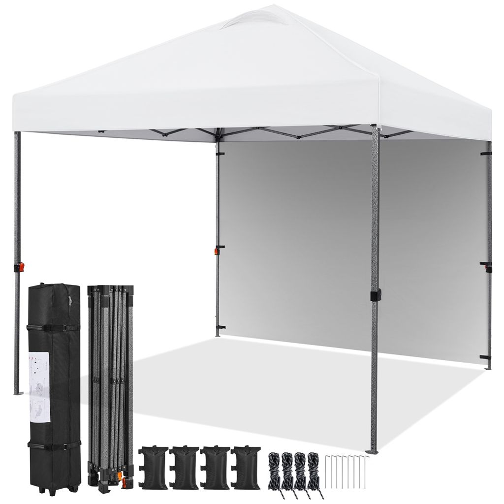 A white pop-up canopy tent is set up, with its frame and a side wall visible. Accessories like a carrying bag, folded frame, weights, and stakes are laid out in front of it.