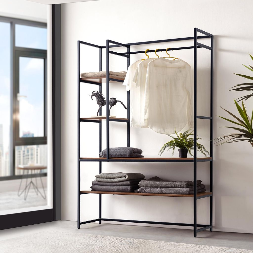 A wardrobe stand with clothes and decorative items, placed indoors near a window.