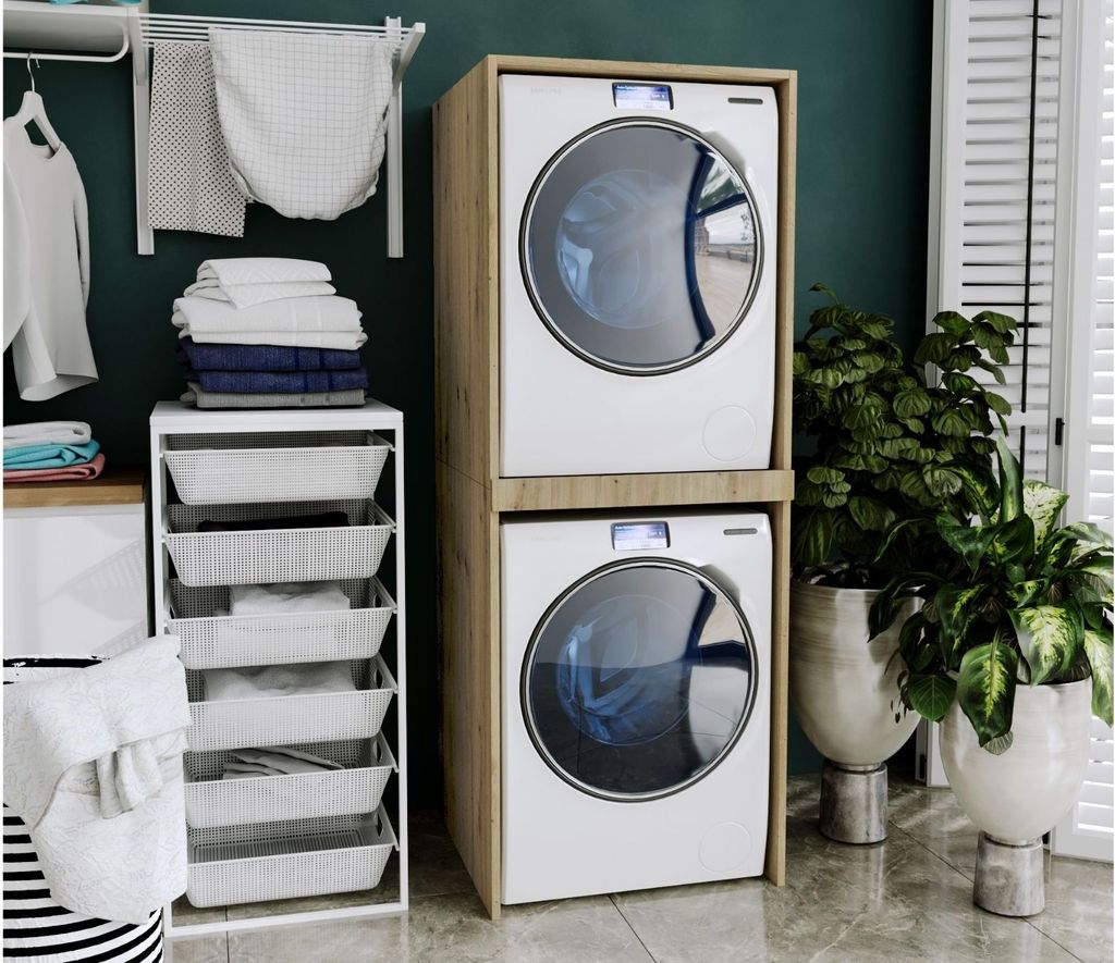 A laundry room with a stacked washer and dryer, storage shelves, and plants.