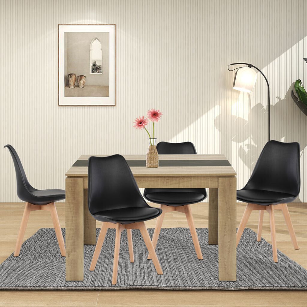 A dining table with four chairs in a well-lit room.