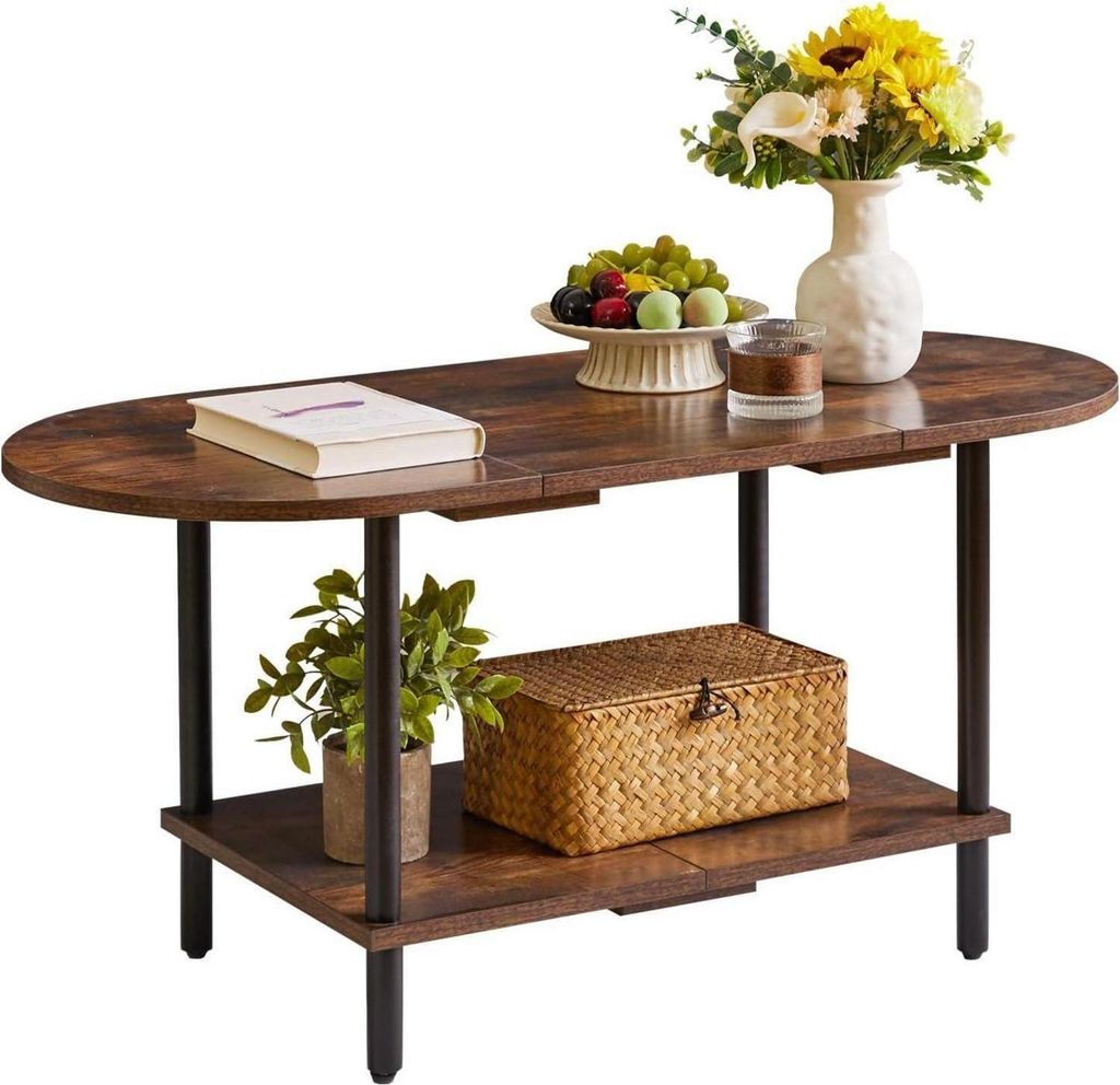 A dark brown oval coffee table with two shelves, decorated with a book, a fruit bowl, a vase with flowers, a small plant, and a woven basket.