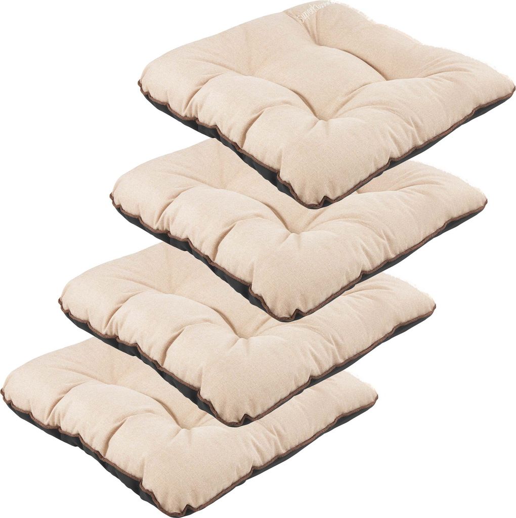 A stack of four beige outdoor seat cushions with dark brown trim, presented on a white background.