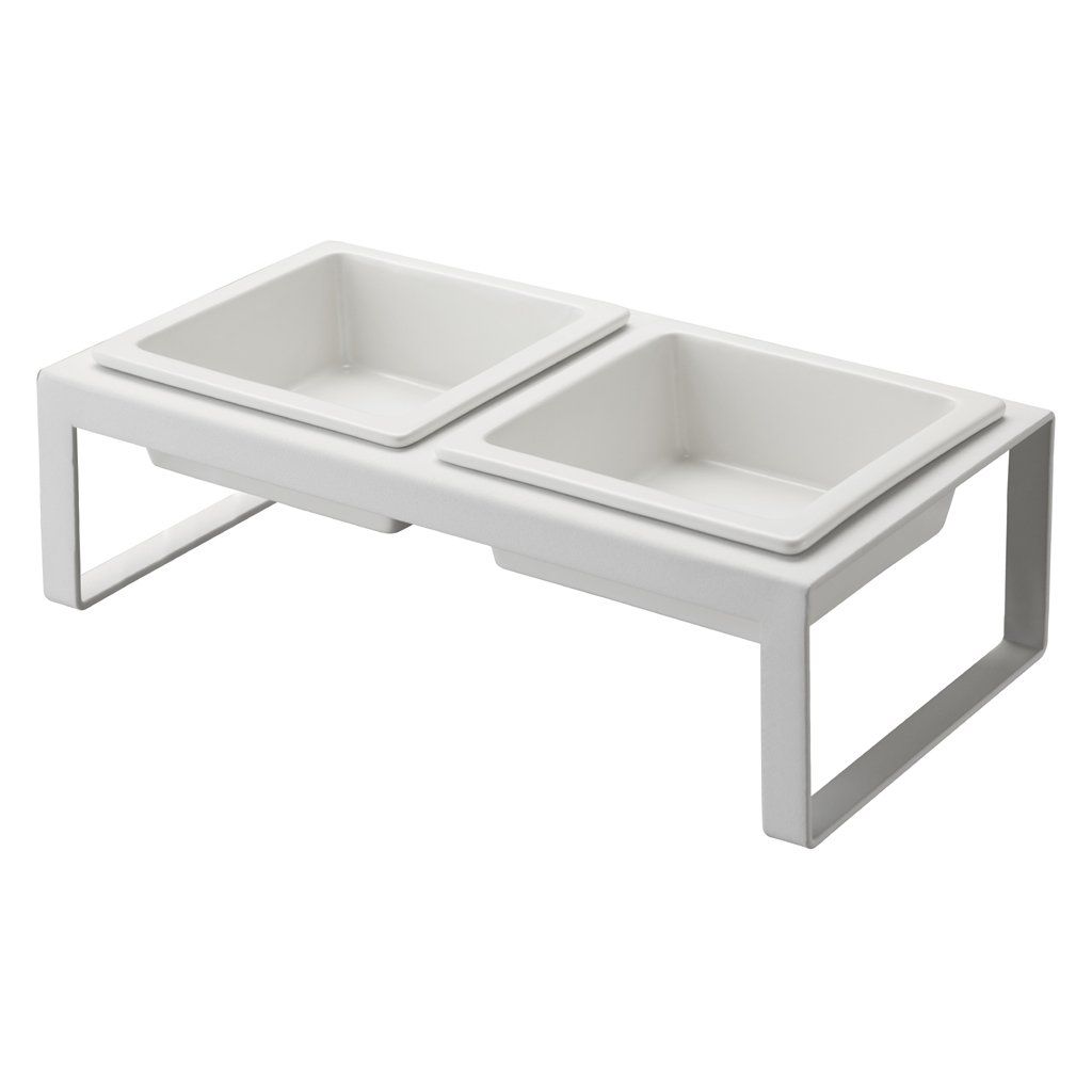 A white, elevated double pet bowl stand with two square ceramic bowls.