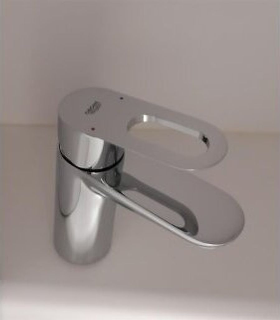 A chrome faucet on a white surface.