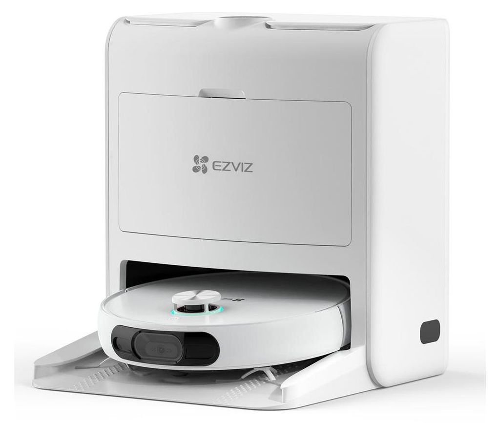 A white robot vacuum cleaner is docked in its charging station.